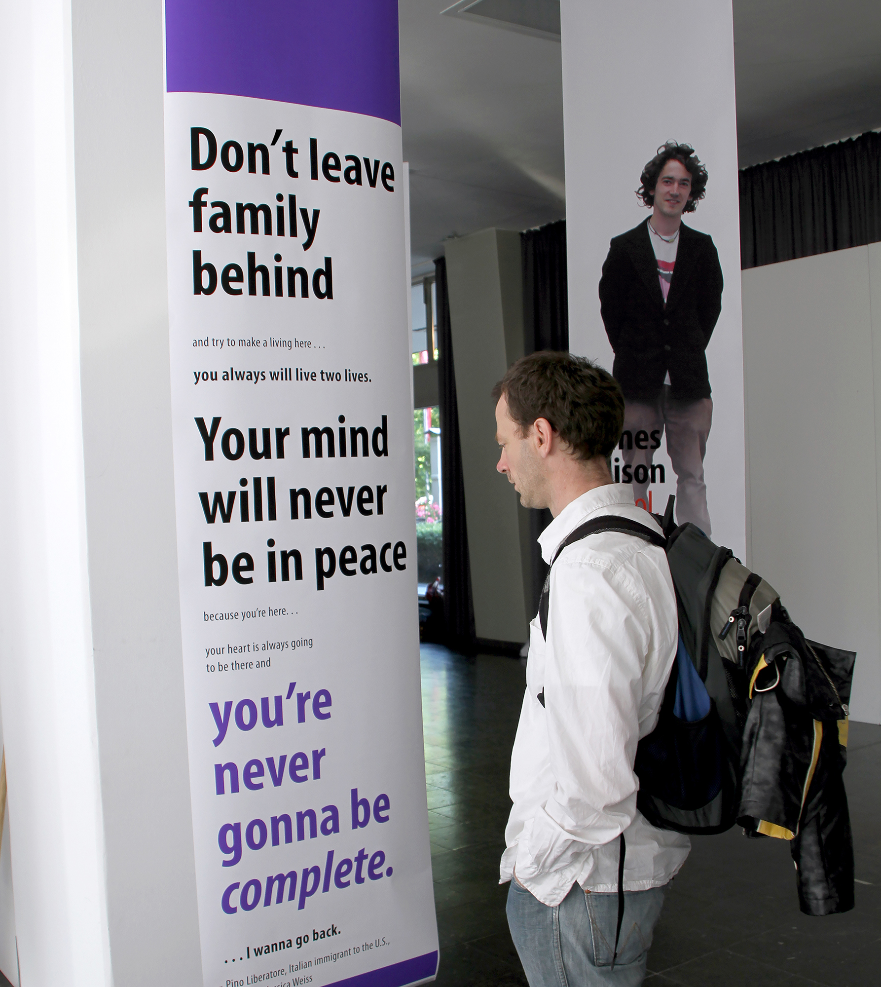 An exhibit goer looking at a poster. The poster says don't leave family behind.